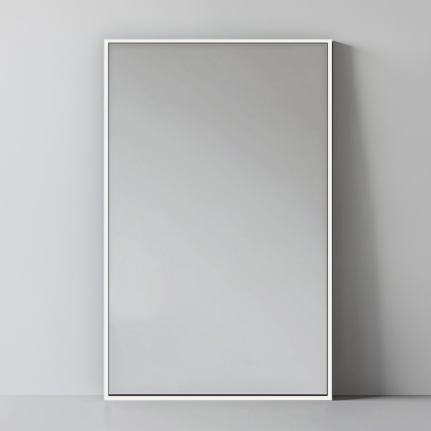 Rectangular Aluminium Mirror - Wall Mirror | 60x90 cm, Thin Frame in matte white, leaning against a grey wall for a soft modern look.