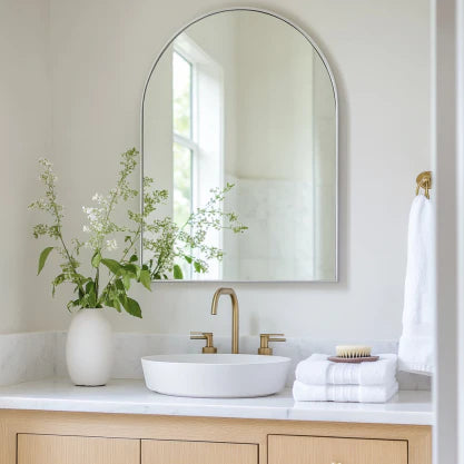 70x55cm Arch Mirror - Aluminum Elegance mounted above a modern bathroom vanity with gold fixtures and white decor. Slim, durable frame adds style and light.