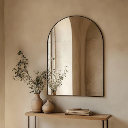 70x55cm Arch Mirror with slim aluminum frame mounted on a beige wall above a wooden console table, reflecting natural light and soft decor.