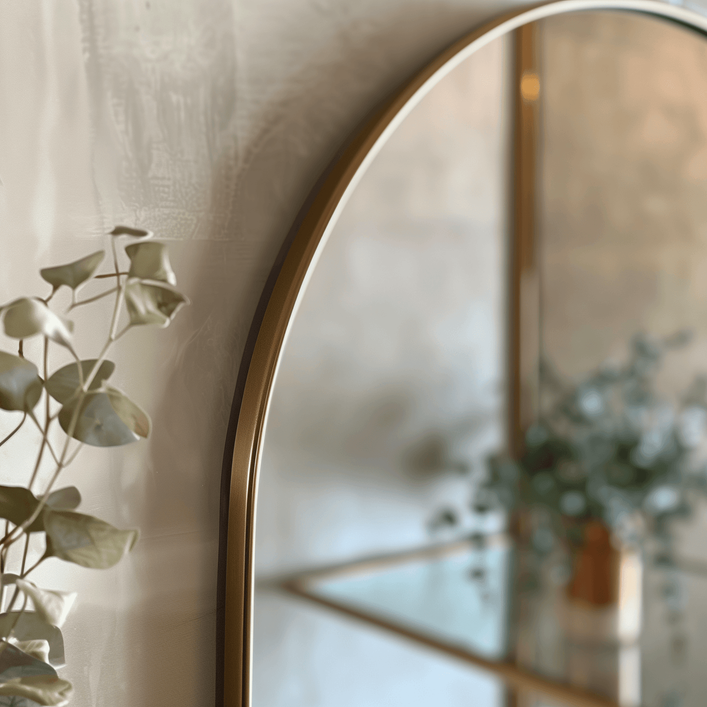 Detail view of gold-framed Arch 70 x 55cm Duo mirror with eucalyptus decor, highlighting its premium aluminium craftsmanship.