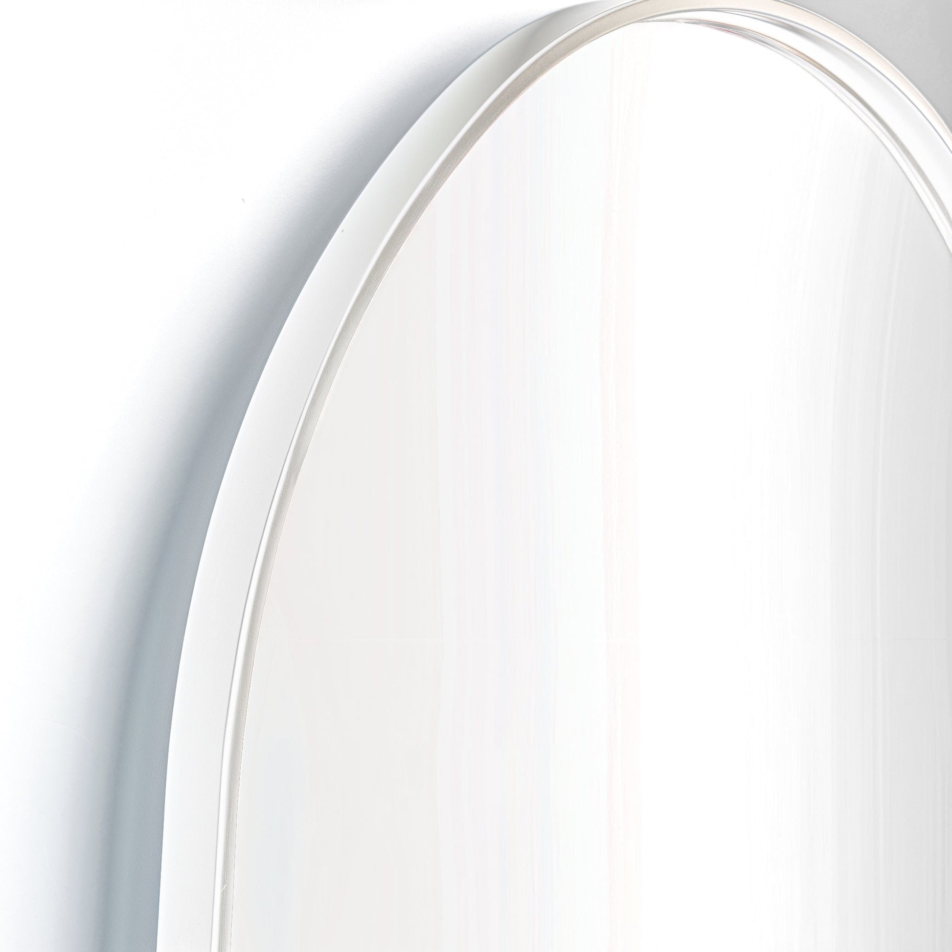 Close-up of white-framed Arch Aluminium Mirror 60x90. Smooth curve and clean lines reflect minimalist design ethos.