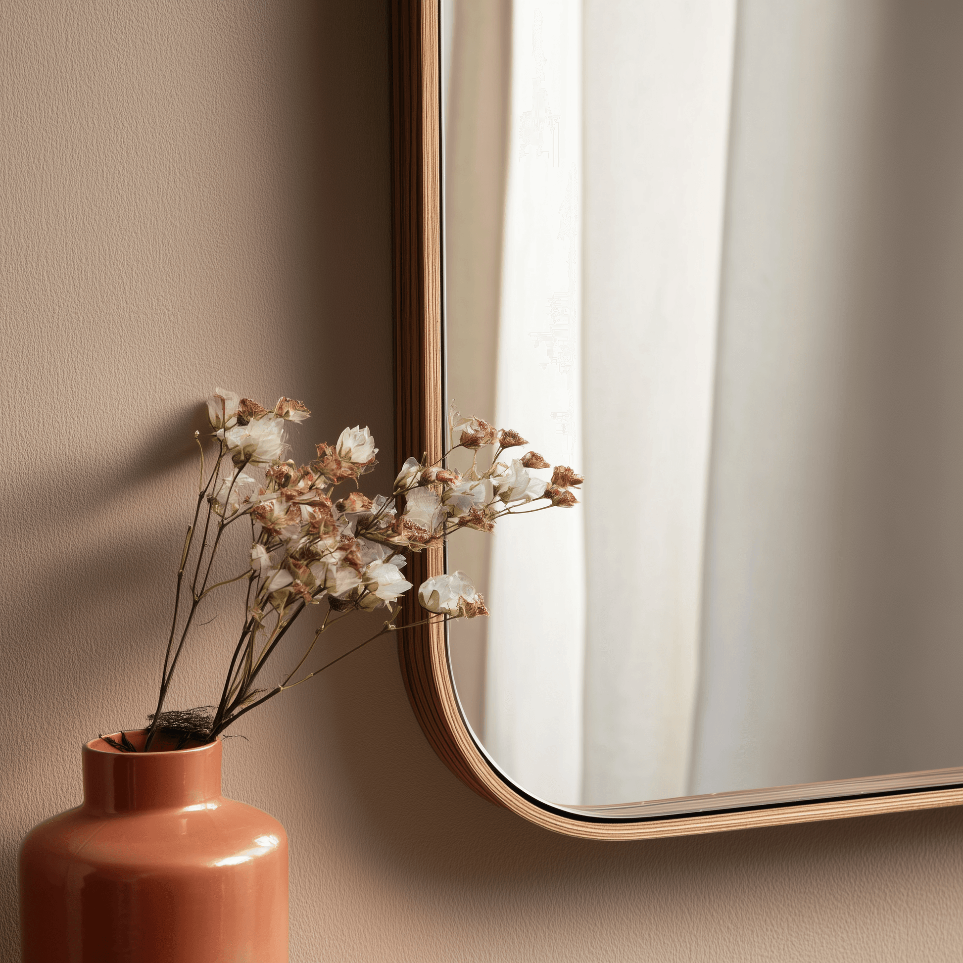 Close-up of African Walnut framed wall mirror with dried flowers in a terracotta vase, showcasing natural wood grain and soft elegance.