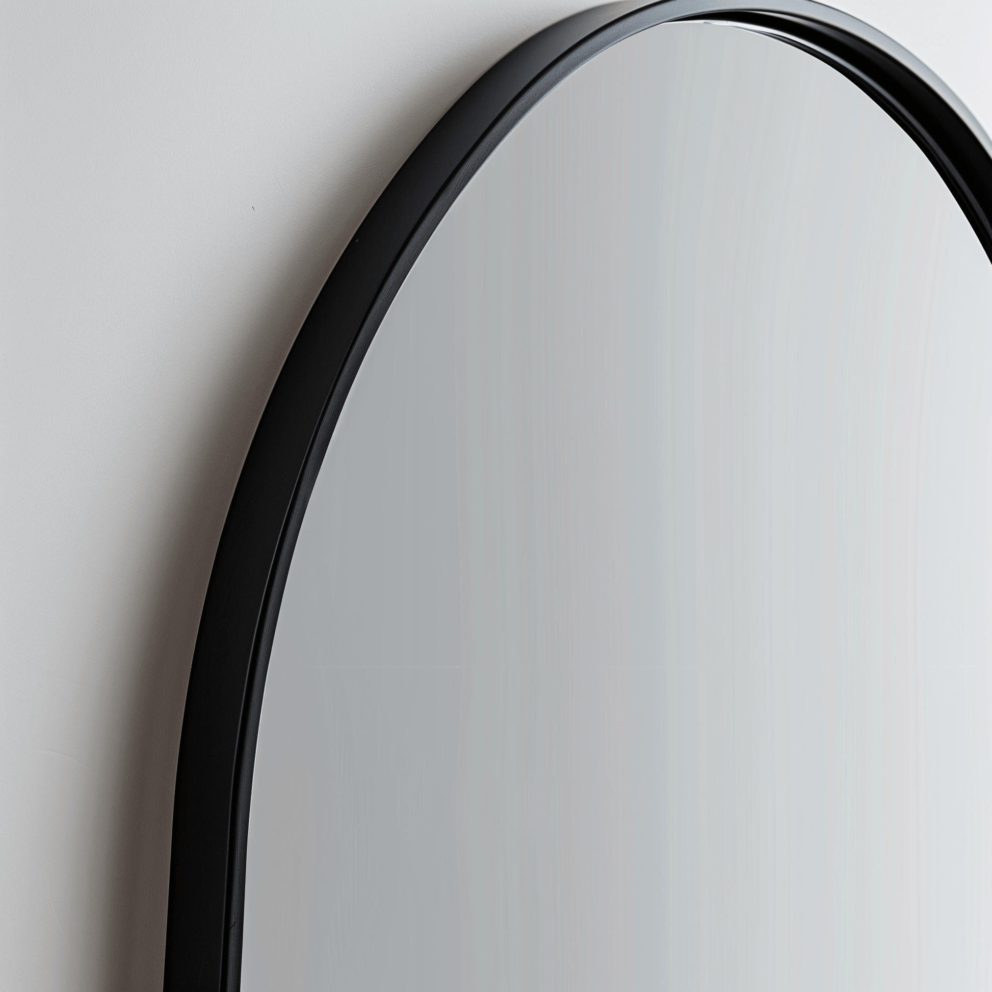 Close-up of black-framed Arch 70 x 55cm Duo mirror, emphasizing the smooth curve and sleek aluminium edge.