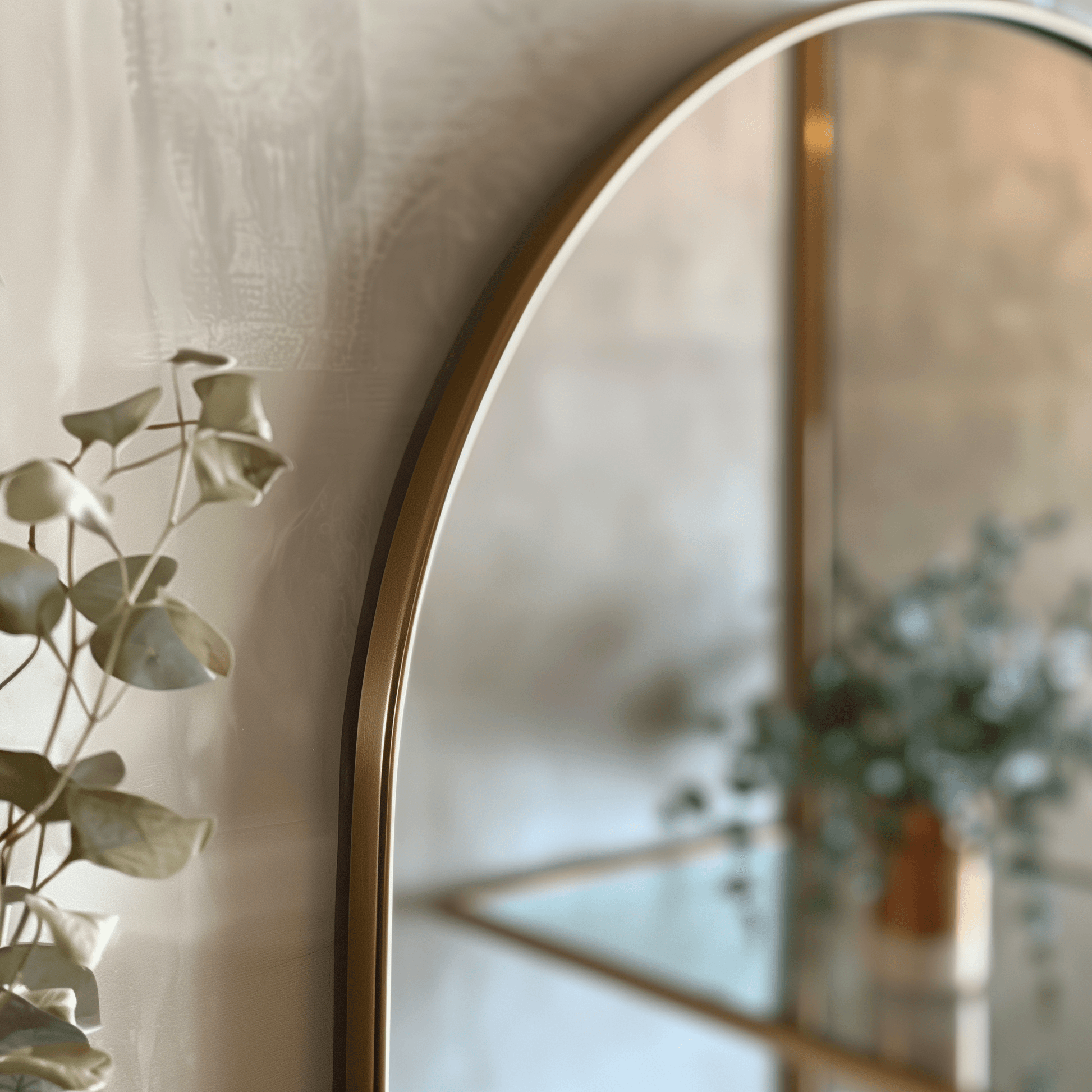 Detail view of gold-framed Arch 70 x 55cm Duo mirror with eucalyptus decor, highlighting its premium aluminium craftsmanship.